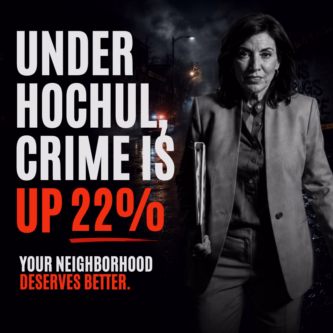 Kathy Hochul in a gray suit holding a folder on a dark, wet street at night with police car lights in the background. Text: 'Under Hochul, crime is up 22%. Your neighborhood deserves better.'
